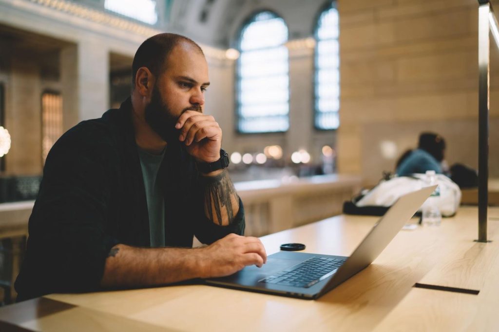 Homem pensativo em frente ao notebook